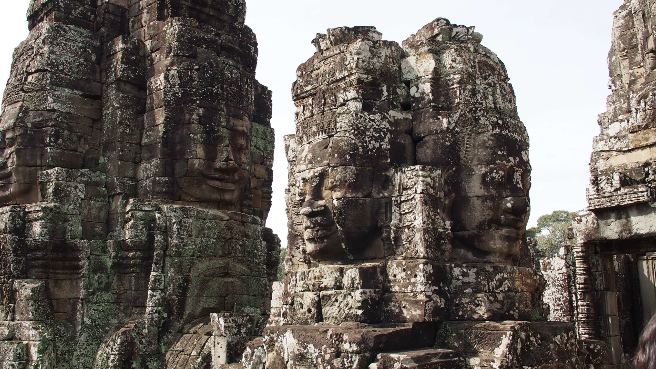 Large stone faces carved in stone decorate the temples of Angkor Wat.